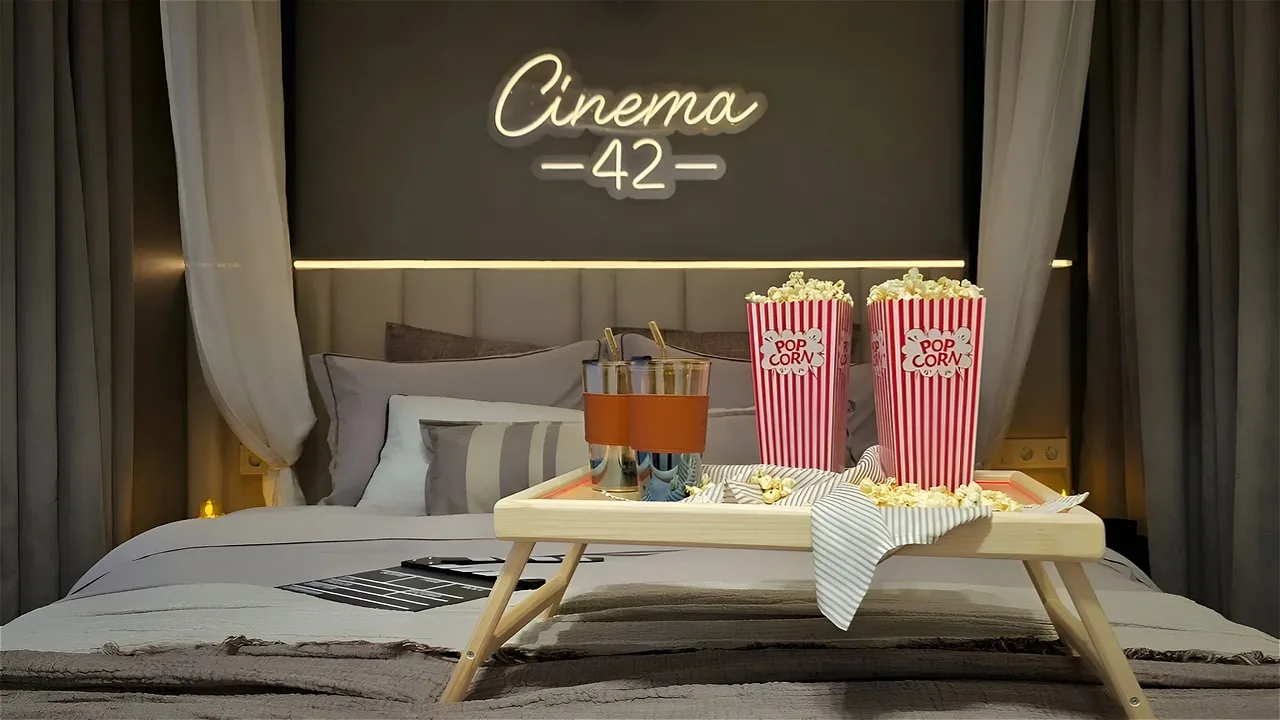 Попкорн и хлопушка на кровати в киноквартире Cinema 42